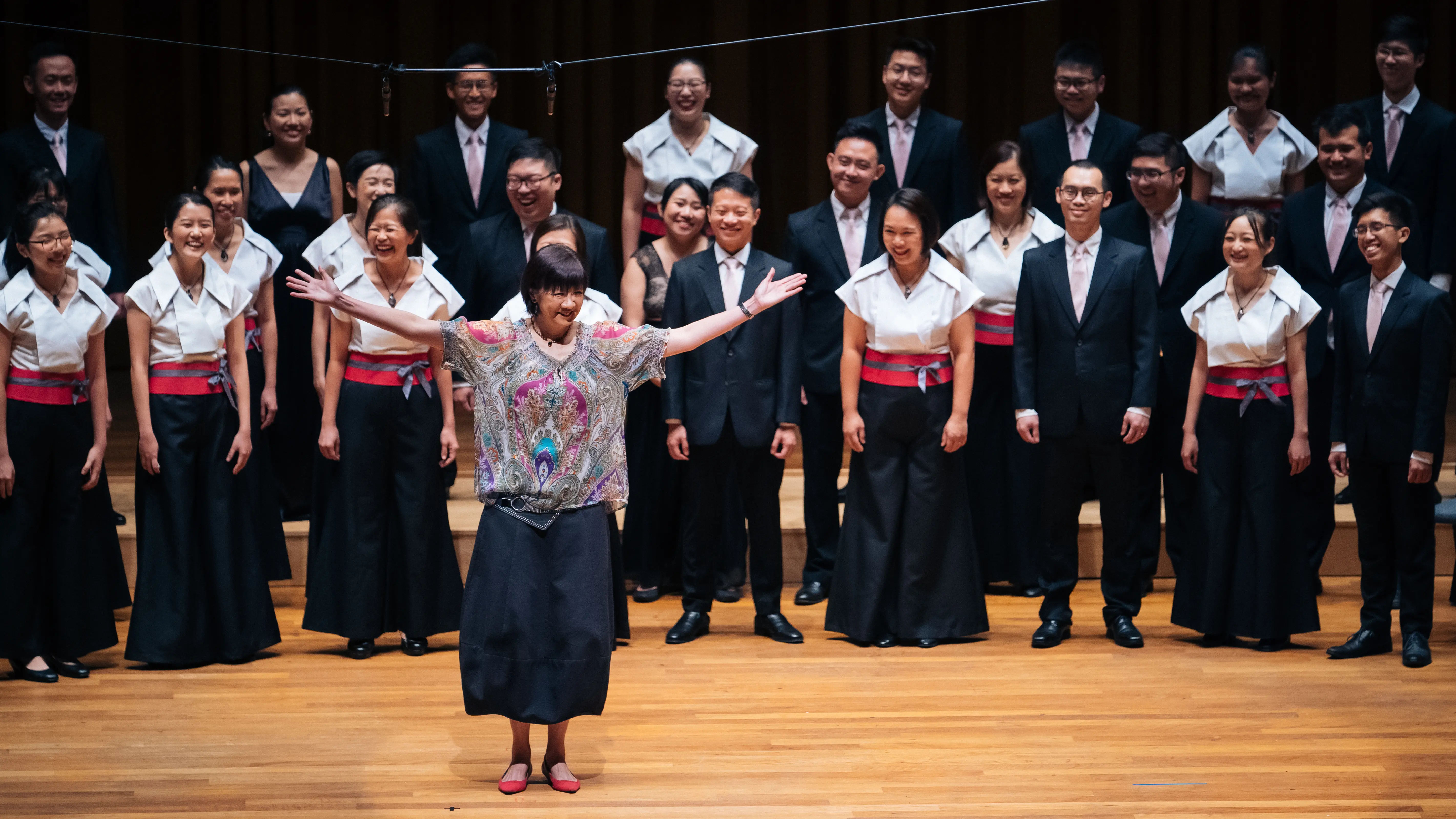 image of choir and conductor facing the audience at a concert